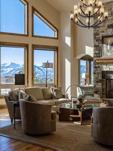 Interior Makeovers Collections 9 Living room with large windows and a decorated sitting area with a large chandelier.